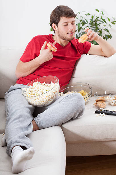 istock Couch potato eating junk food 503624151