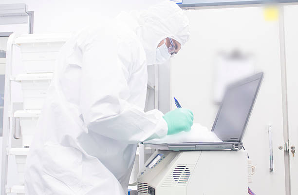 Pharmaceutical formulation Scientist Pharmaceutical scientist working in an aspeptic or sterile or clean room fully gowned and performing qualification of equipment. cleanroom stock pictures, royalty-free photos & images