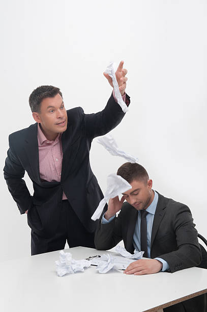 istock Boss angry with young employee sitting at desk 503625611