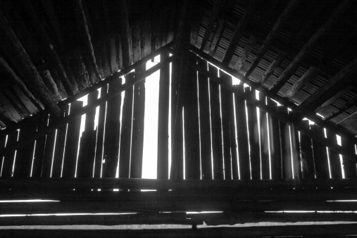 A missing plank in an old barn house in the rural Finland.