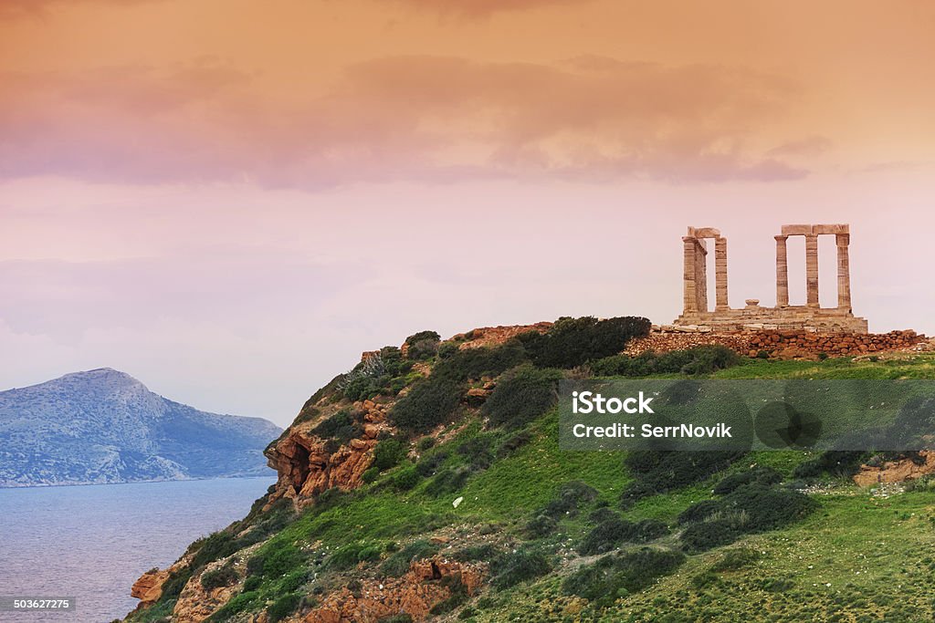 Temple of Poseidon on green hill near sea, Greece Temple of Poseidon on cape Sounion, Greece on Mediterranean sea close to Athens Cityscape Stock Photo