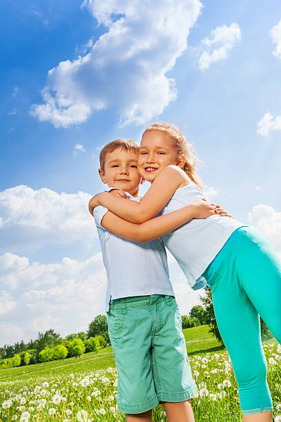 istock Funny kids hugging together on a meadow 503627317