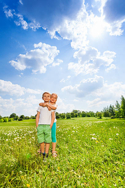 istock Two children stand together on a meadow 503627321