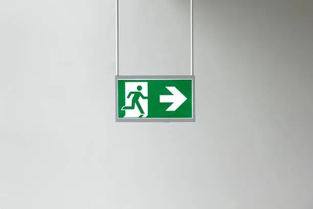 Closeup of modern illuminated emergency exit sign .