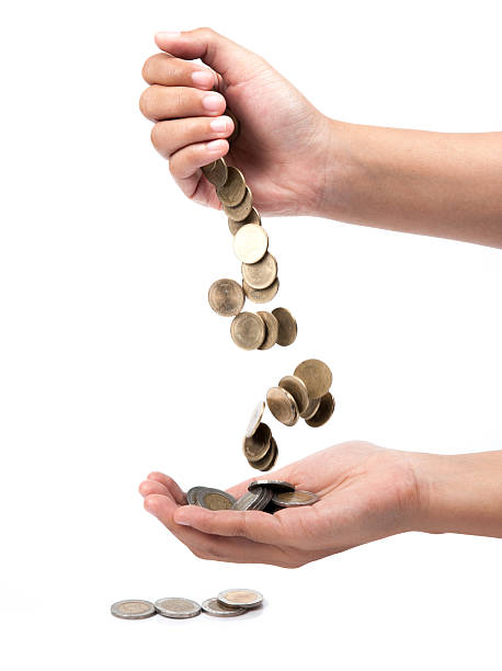istock hand pour down coins into hands of another person. 503627889