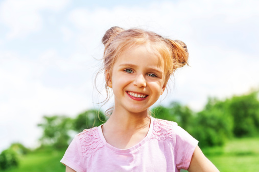 Young white elementary aged girl looking at camera and smiling