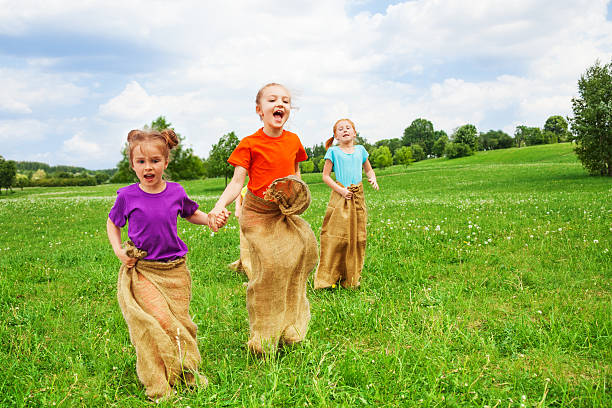 istock Kids jump in sacks on a grass 503628357