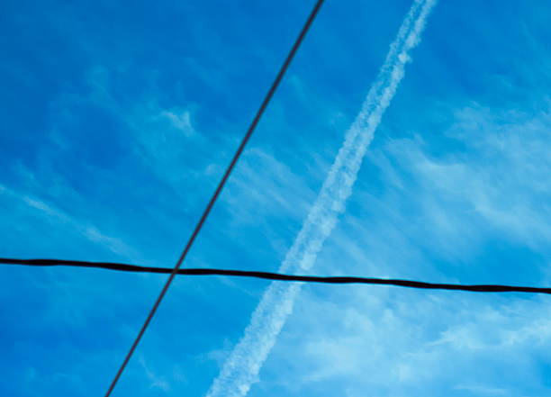 Lines on sky, wires and plane trace, with copy/text space.