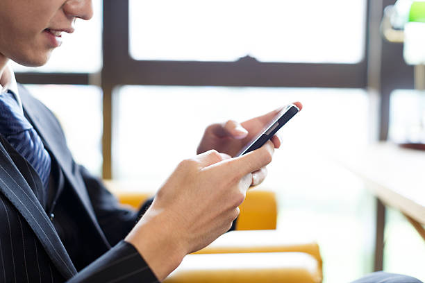 istock people playing with cell phone in cafe 503635486
