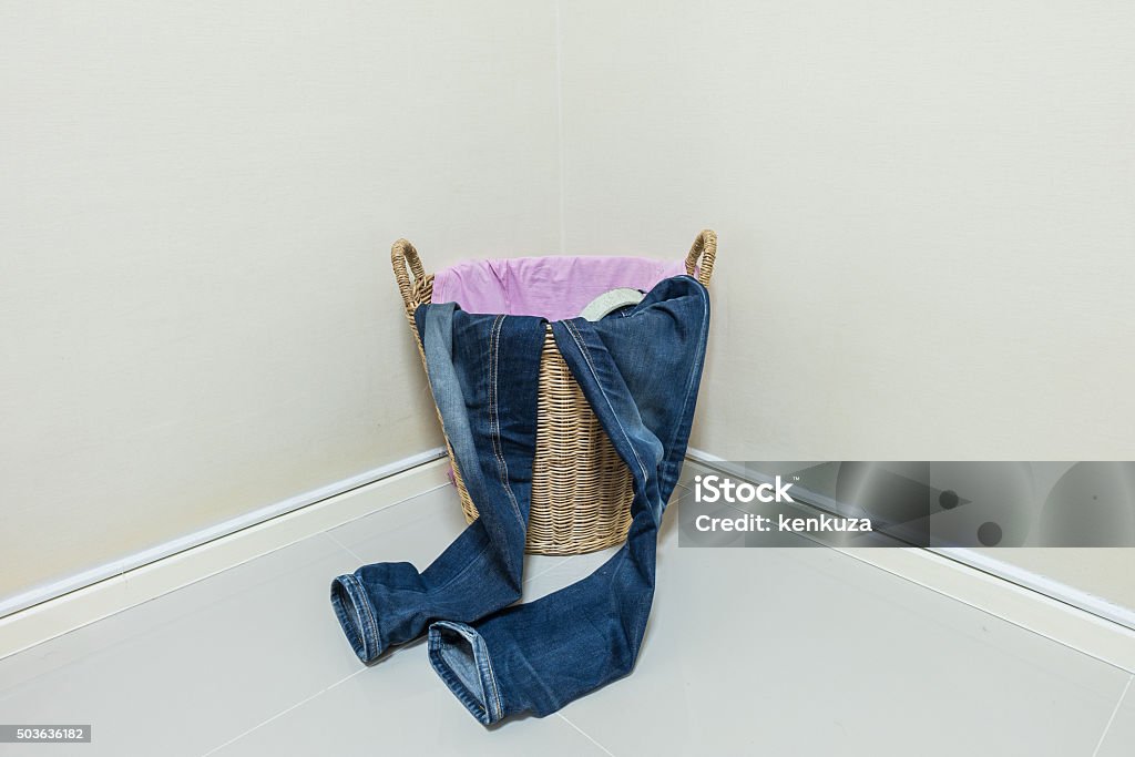 Used clothes in wood basket at corner in room Adult Stock Photo