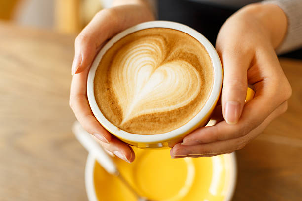 istock lady's hands holding cup with sth heart-shaped 503636418