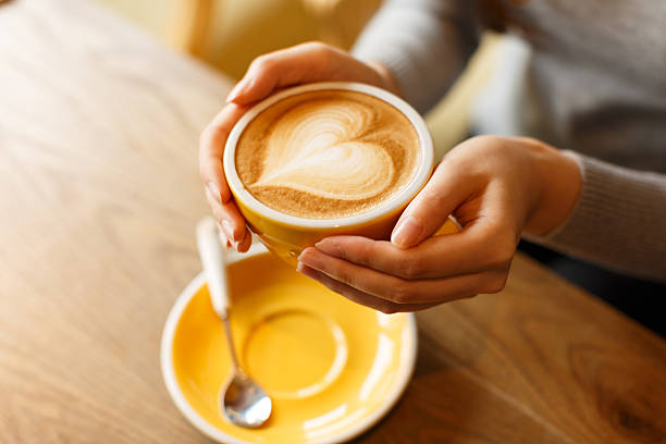 istock lady's hands holding cup with sth heart-shaped 503636446