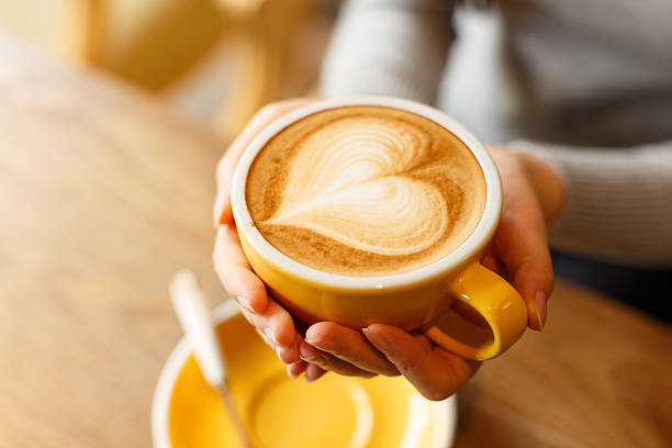 donna mani tenendo la tazza a forma di cuore con sth - latté coffee cafe cappuccino foto e immagini stock