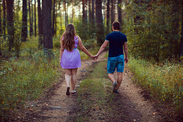 istock Romantic couple go  and holding hands on background summer forest 503640104