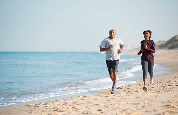 istock Couple running outdoors on sandy beach. 503640234