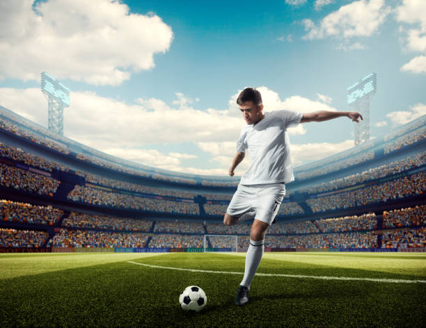 Soccer player kicking ball in stadium