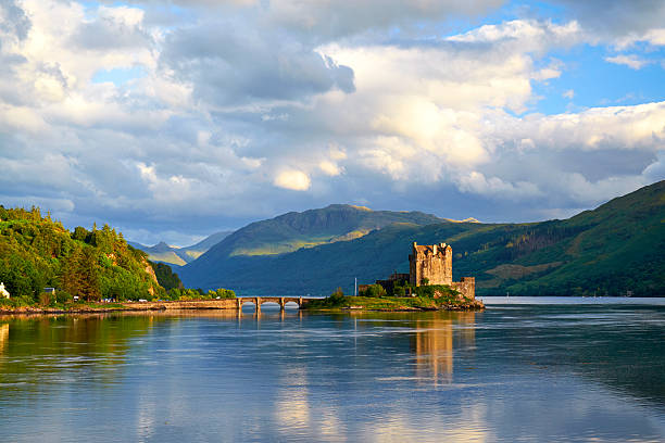 Eilean Donan In Scotland Dornie, Scotland - August 3, 2015: Afternoon sunlight falls upon the iconic form of Eileen Donan Castle in Scotland. The waters of Loch Alsh, Loch Duich and Loch Long meet close to the tidal island upon which the castle sits. scottish highlands castle stock pictures, royalty-free photos & images