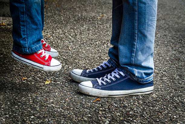 istock The man raised his sneakers child red sneakers from the ground. 503656310