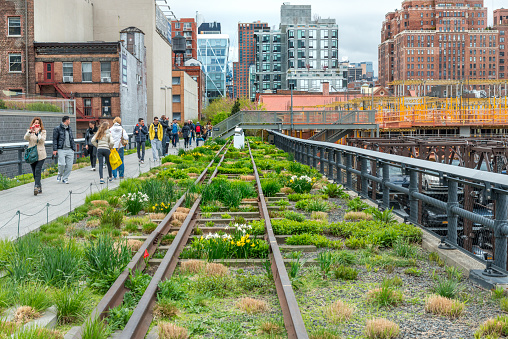New York, United States - April 29, 2014: People walk along the High Line Park. The High Line is a popular linear park built on the elevated former New York Central Railroad spur in Manhattan.