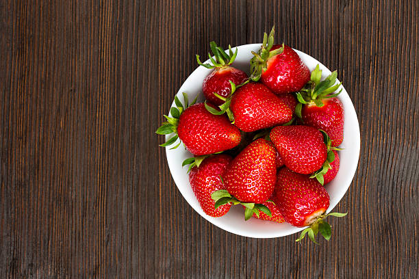 Fresh ripe strawberries in a simple white bowl