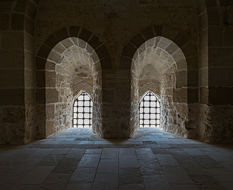 Ancient stone wall with two adjacent backlit windows, Qaitbay Castle
