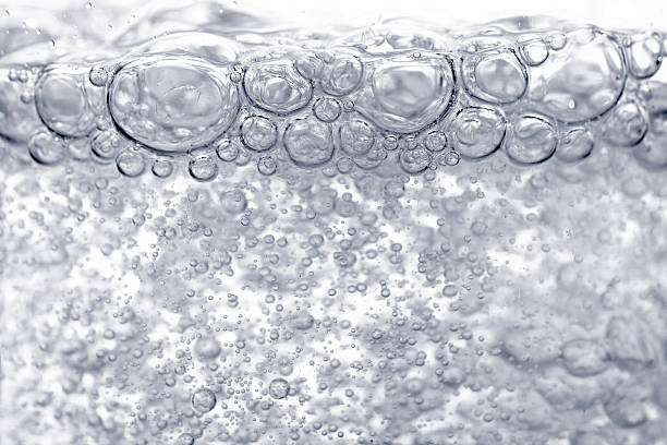 burbujas en el agua hirviendo - hervir fotografías e imágenes de stock