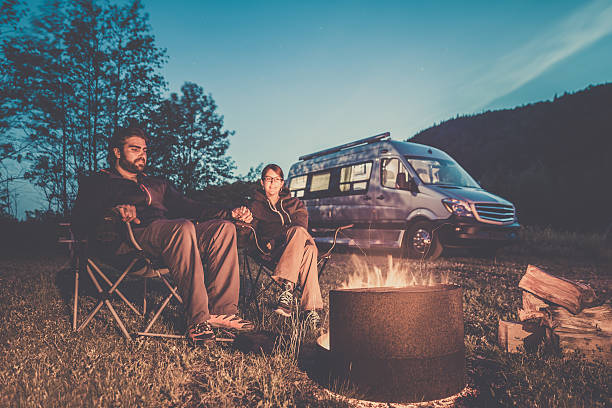 istock Couple Sitting Next to Campfire with Camper Van 503662764
