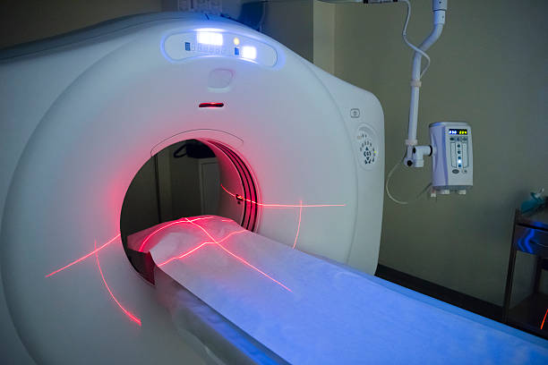 Empty CT scanner in hospital showing bed and red lights CAT scan machine with empty bed. PET scan equipment. Medical scanning equipment. pet scan photos stock pictures, royalty-free photos & images