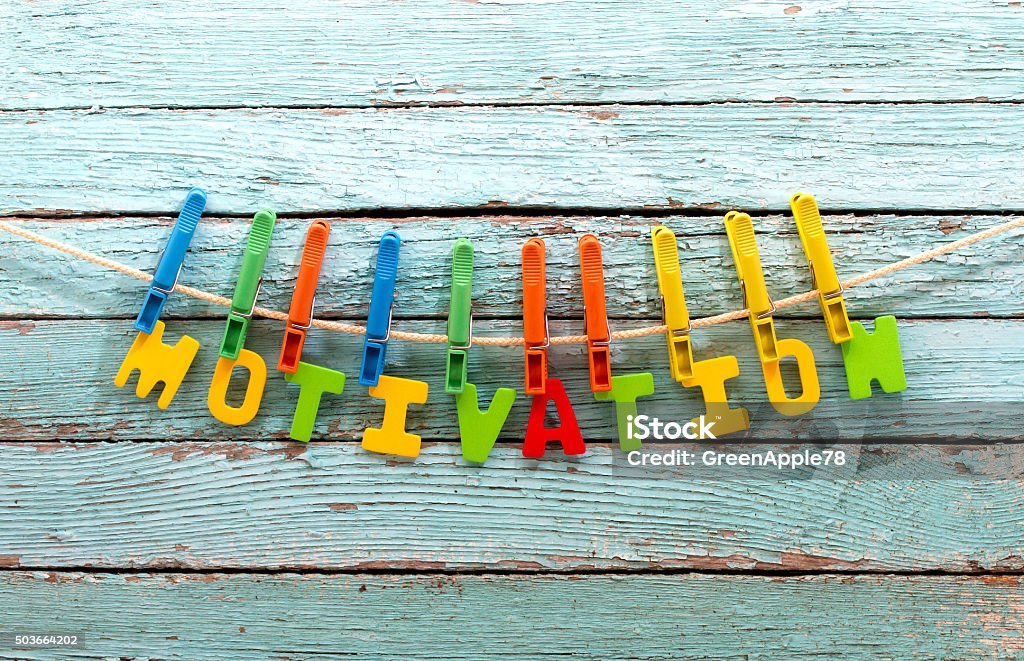 motivation word motivation fasten clothespins on a rope behind a wooden background Achievement Stock Photo