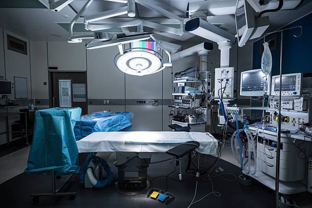 operating theater mit leeren bett und medizinisches gerät - operationssaal stock-fotos und bilder