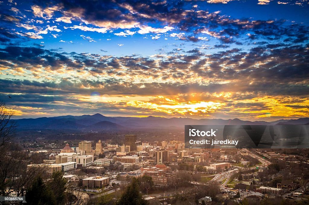 Sunset over Downtown Asheville North Carolina NC Epic Sunset over Downtown Asheville North Carolina NC cityscape with blue ridge mountain range and Mt. Pisgah featured in the background. Asheville Stock Photo