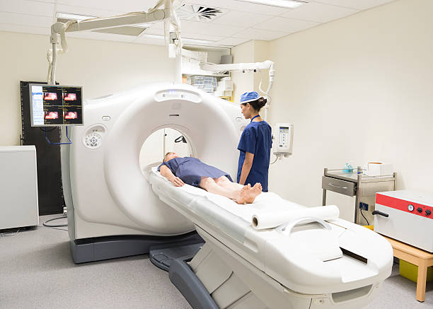 Radiologist watching patient in CAT scanner in hospital Woman in having CAT scan with radiologist by machine. PET scan equipment. Medical scan of patient. Radiography. pet scan photos stock pictures, royalty-free photos & images