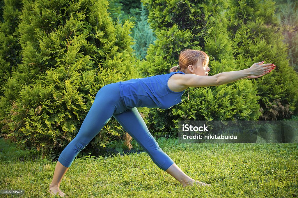 Beautiful woman practicing fitness or yoga Beautiful young woman doing yoga exercises outdoors Activity Stock Photo