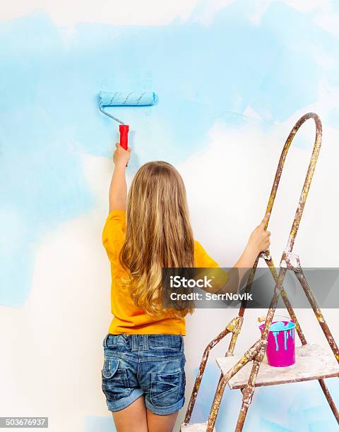 Little Girl Paints The Wall Standing On A Ladder Stock Photo - Download Image Now - Back, Beautiful People, Beauty