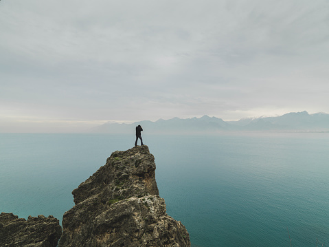 Man standing alone top of cliff for taking photographs