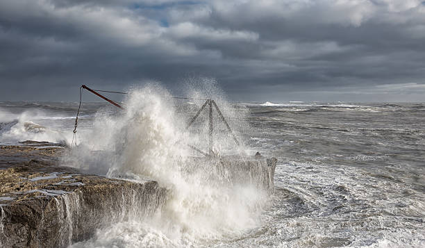 Fisherman's Crane. A fisherman's crane at Portland Bill in Dorset being swamped by a winter storm. bill of portland stock pictures, royalty-free photos & images