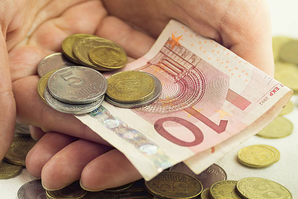 istock Lots of coins different values  ten euros and hand 503684504