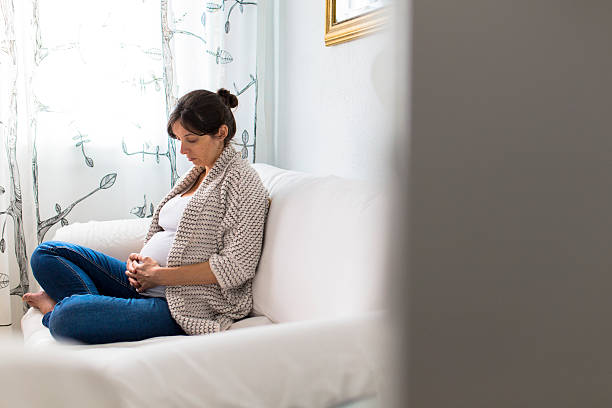 Mujer embarazada looking at her belly - foto de stock