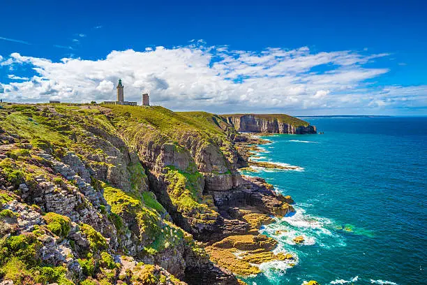 Panoramic view of scenic coastal landscape with traditional lighthouse at famous Cap Frehel peninsula on the Cote d'Emeraude, commune of Plevenon, Cotes-d'Armor, Bretagne, northern France