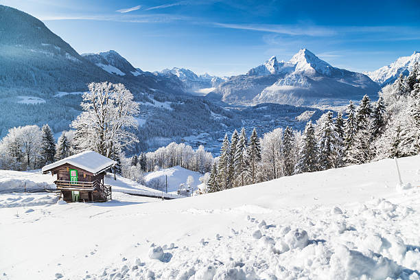 Winter wonderland with mountain chalet in the Alps Panoramic view of beautiful winter wonderland mountain scenery in the Alps with traditional mountain chalet on a cold sunny day with blue sky and clouds european alps stock pictures, royalty-free photos & images