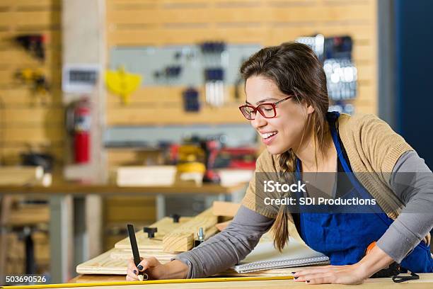 Young Artist Smiling While Creating Something With Wood In Makerspace Stock Photo - Download Image Now
