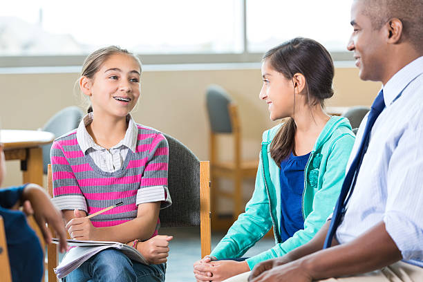 istock Elementary girls meeting with teacher during after school program 503690638