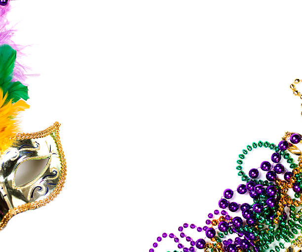 Mardi Gras background. Purple, gold, green, mask, beads. Mardi Gras background. Colorful green feathers decorate the beautiful gold masquerade mask with beads in purple, gold, and green Mardi Gras colors. The objects are placed on a white background with copyspace center. The Mardi Gras festival is held every year in New Orleans Louisiana, USA. purple and gold masquerade masks stock pictures, royalty-free photos & images