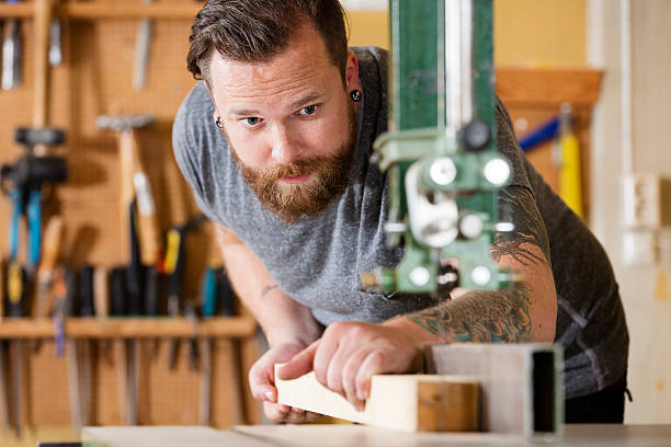 istock Craftsman using bandsaw for splitting wood plank in workshop 503691878