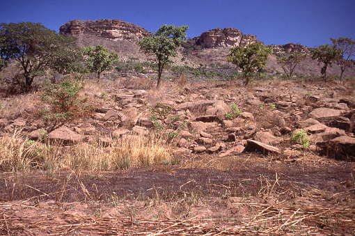 Late dry-seaon view of rural landscape below rocky escarpment central Togo West Africa