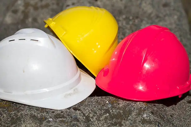 Photo of Three Safety hardhats representing concepts or teamwork ideas