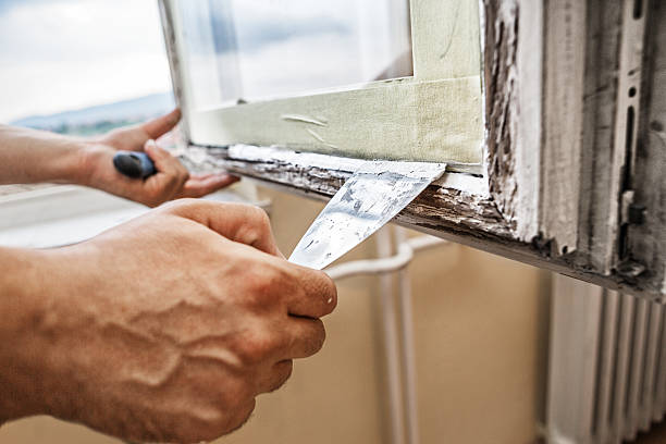 Repairing a window frame Man using scraper and putty for renovation old windows latch photos stock pictures, royalty-free photos & images
