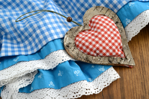 blue Beer Fest Dirndl with red white heart on wooden background. heart made of birch tree wood und cotton.