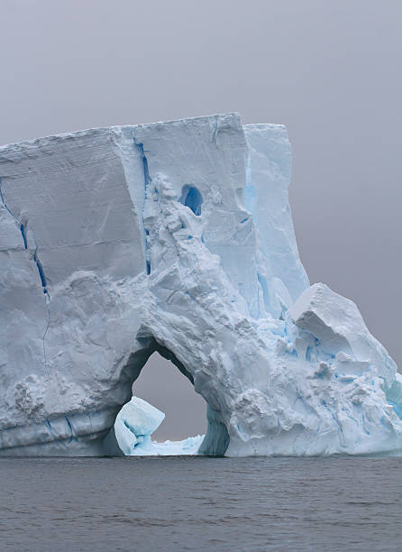 istock Iceberg with large through entrance on a cloudy day 503701589