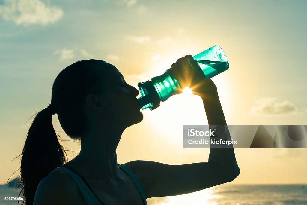 Woman drinking water Beach Stock Photo